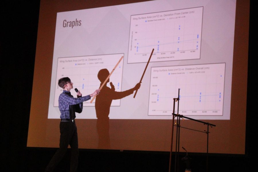 Sophomore+Logan+Larrick+points+to+the+graphs+he+completed+on+his+paper+airplane+experiments+for+his+long-term.