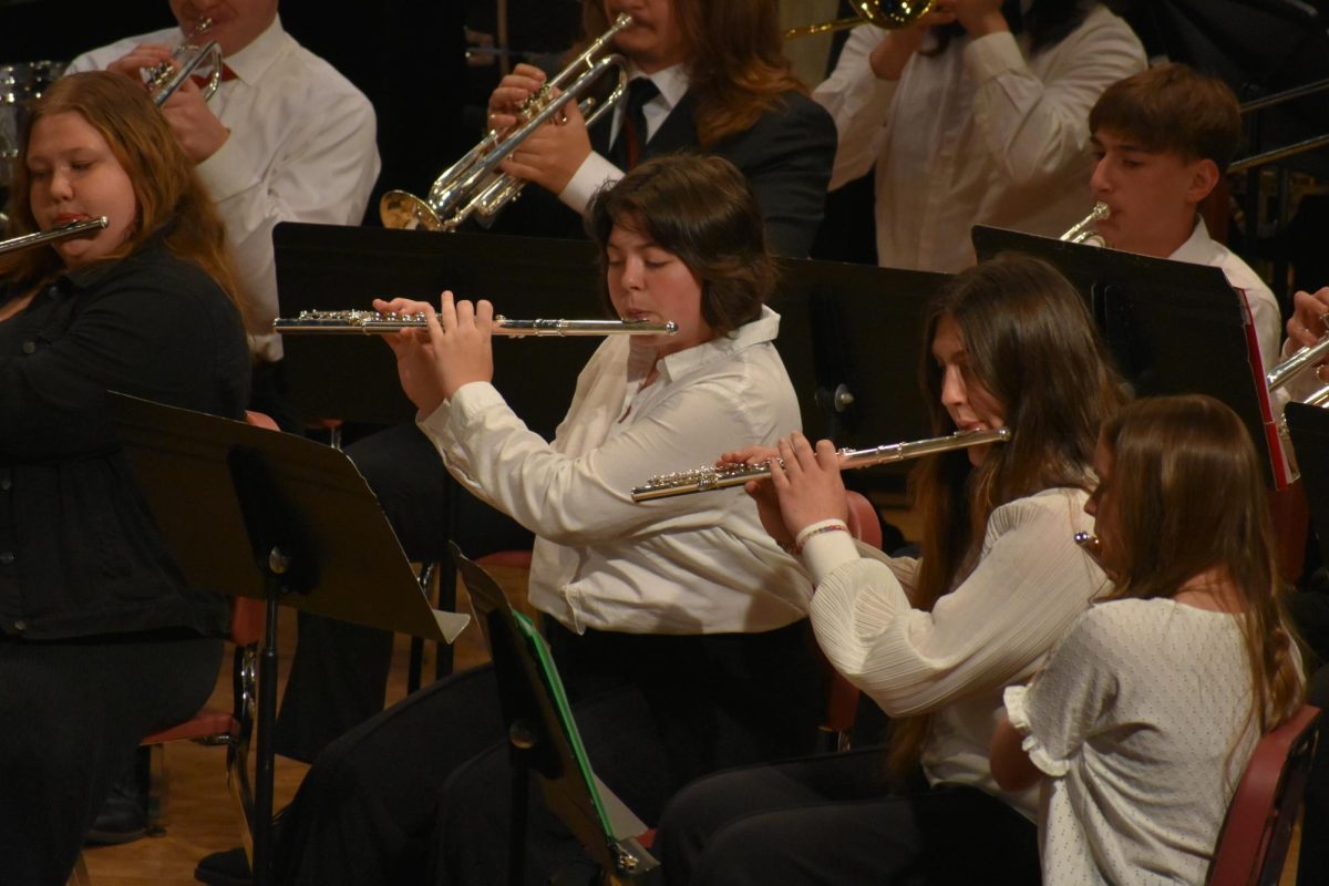 During the concert band performance on May 2, junior Lilly Burgess (center) played alongside the other students in the flute section.