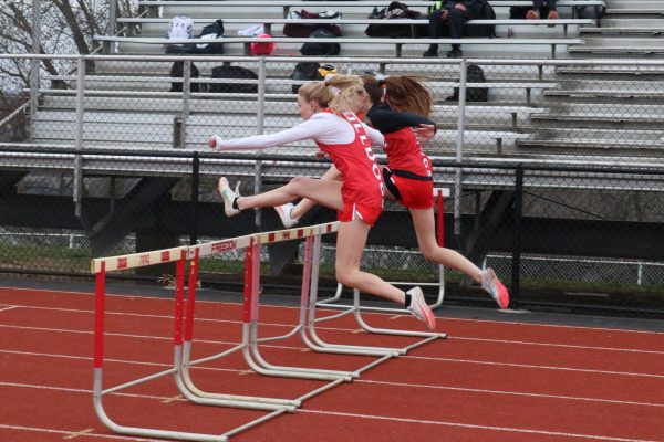 During a home meet on March 22, senior Jersee Melvin and sophomore Riley Tokar jump a hurdle in a very close race