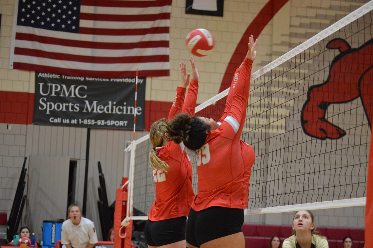 Shut Down: Going up for the block, senior Cassidy Harris and freshman Kameron Haskey try to block the opposing hitter. Blocking is a very important part of volleyball, and used to stop on-coming spikes.