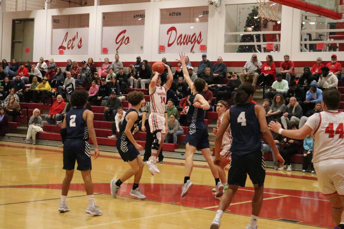 Jump shot: In the air, sophomore Garrett Drutarosky aims the ball at the hoop, hoping to make a shot. The game was held on Monday, Dec. 11, where they fell to the Rochester Rams by a score of 58-25.