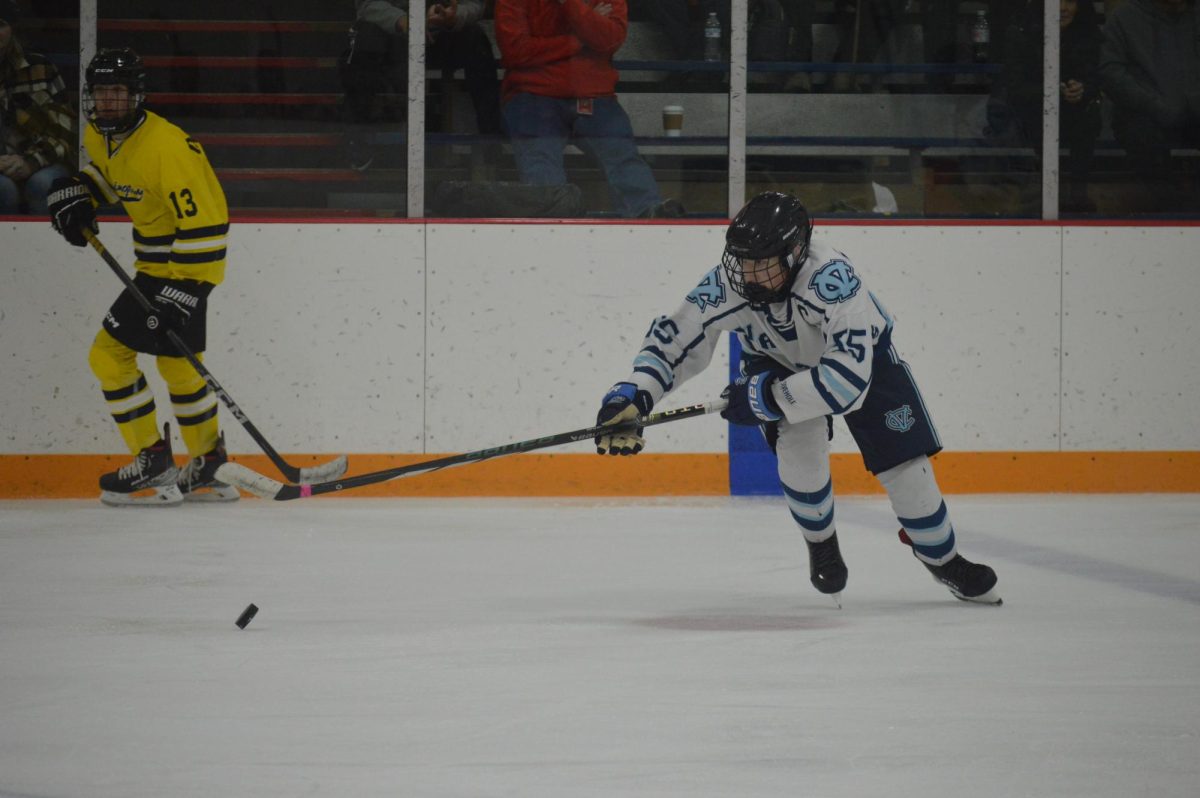 Gaining control: Attempting to defend the goal, senior captain Chase Grable takes control of the puck and sends it to the offensive end to give his teammates an opportunity for a shot on goal.