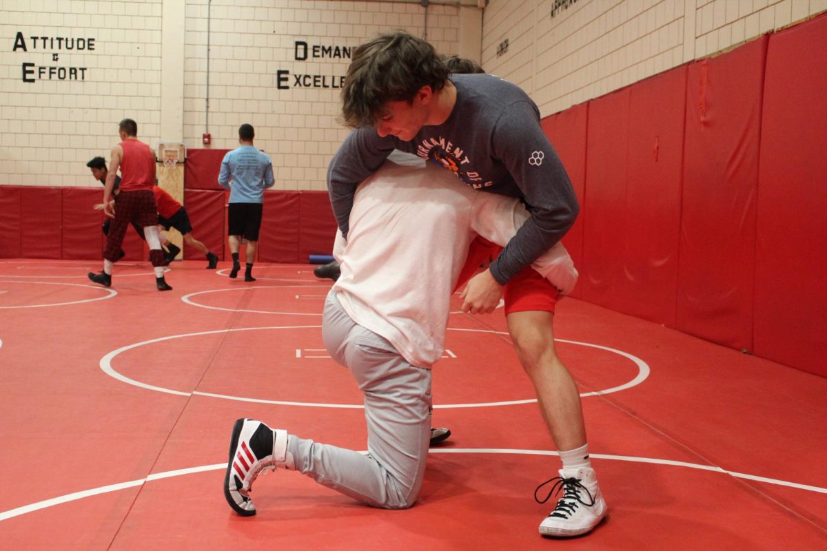 Practice makes perfect: In the mat room, senior Ryan Kredel and junior Gavyn McCray practice together after school on Dec. 14. The wrestling team meets multiple times a week for practice.