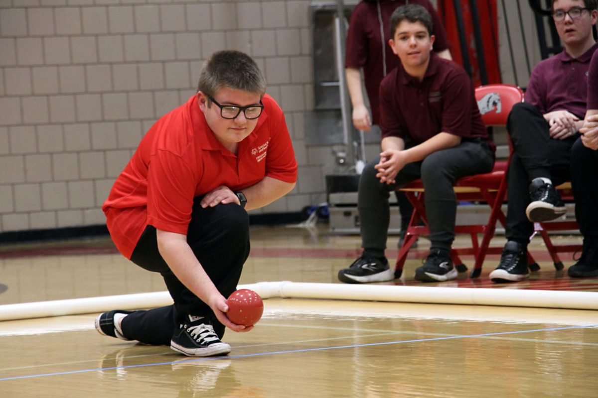 On+a+roll%3A+Kneeling+down%2C+senior+Steffan+Paganie+prepares+to+roll+his+bocce+ball+down+the+court+towards+the+pallino+ball%2C+which+is+the+target.+Freedom+showed+their+school+spirit+as+they+cheered+each+other+on+during+their+turns.+