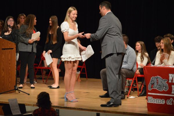NHS ceremony: After reading the senior bios, senior Madison Meyer shakes Principal Mr. Steven Mott’s hand when receiving her pin.