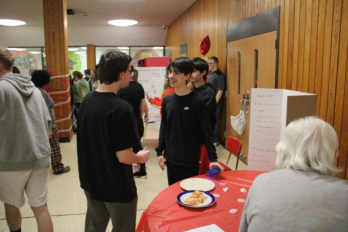 Flavorful facts: Explaining their dish, Lindsay Medwid and Nicholas Medwid tell Zachary Wynn about the food. Many friends spent time going to tables and seeing what their peers created for the night.