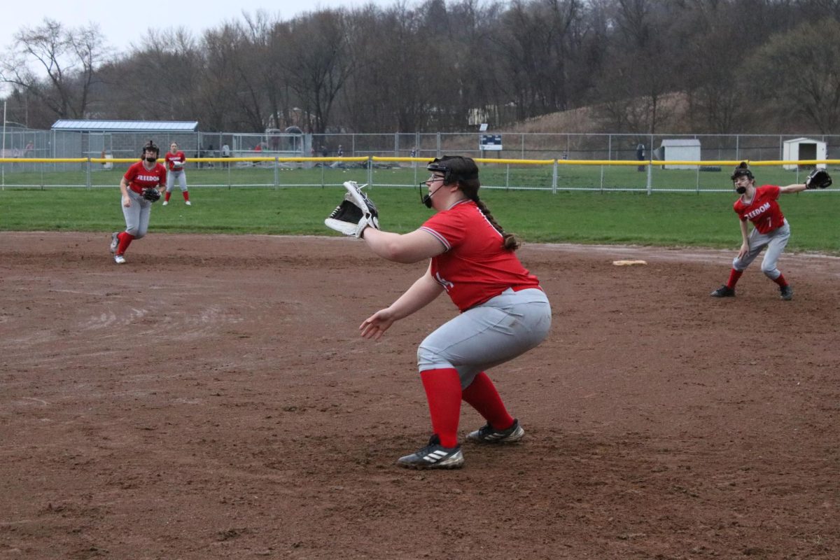 In position: Watching closely, freshman Rylie Vojtko prepares to catch the softball at the scrimmage against Rochester. As first baseman, Vojtko attempts to stop the opposing team from advancing to first base.