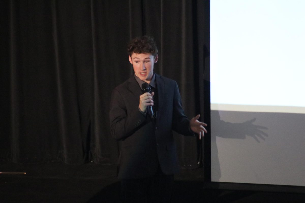 Scientific spotlight: Addressing the audience, senior Chase Grable presents his long-term project in the auditorium. Grable was one of the several Physics III students who presented in the auditorium on May 3.