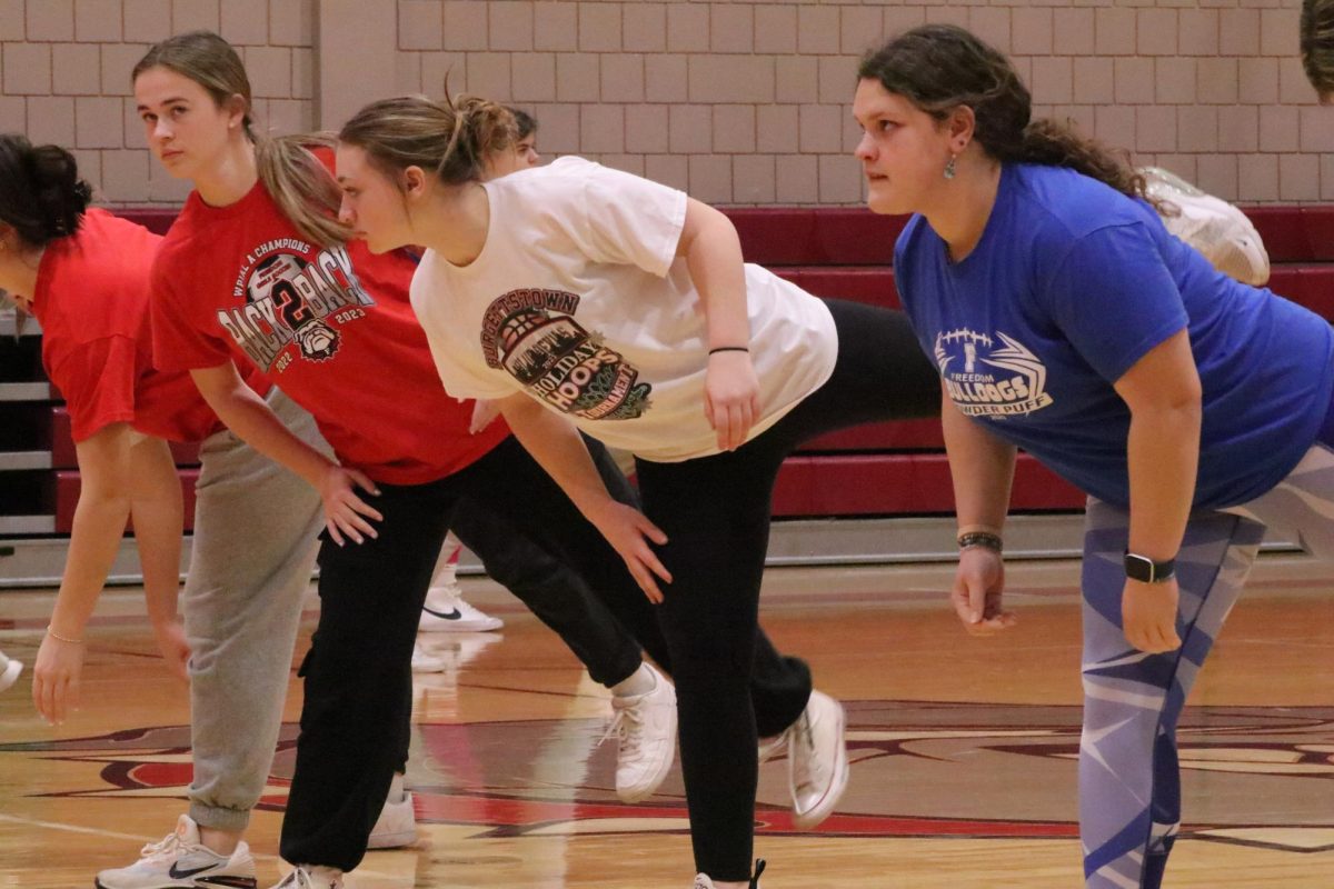 Warming up: Stretching before practice, sophomore Alyssa Bearer warms up her legs before she begins to workout. Stretching is a vital part to having a good and safe practice. 