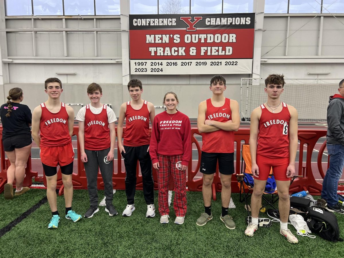 Competition ready: Smiling together, members of the indoor track team stand in front of the Youngstown State University’s (YSU) Track and Field sign. Starting in January, the Bulldogs went to a few meets hosted at YSU’s campus.