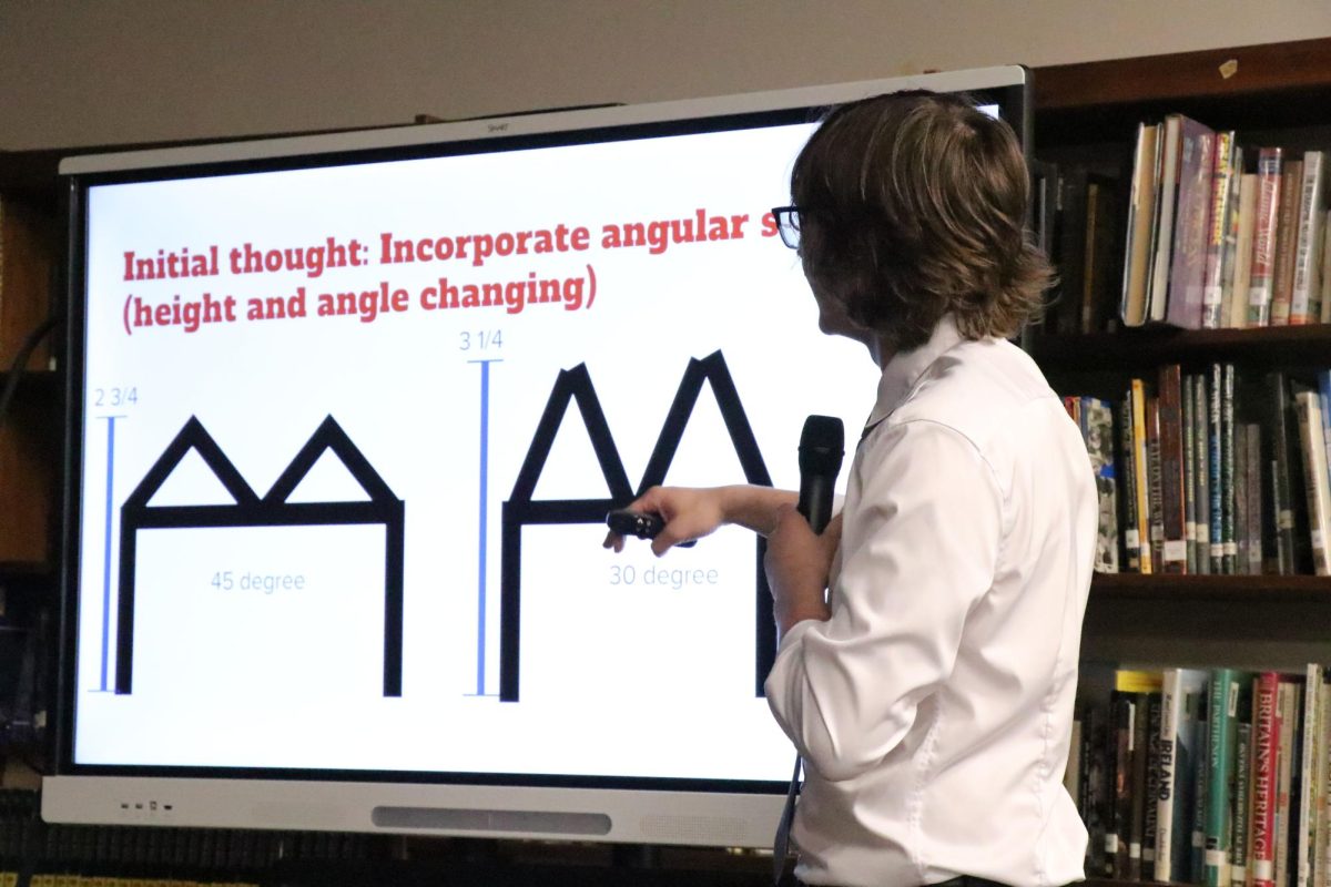Keeping it steady: In the high school library, Arthur Evans (11) presents his long-term project to a group of students. Evans' project analyzed what height and angles were prime for designing a functional bridge.