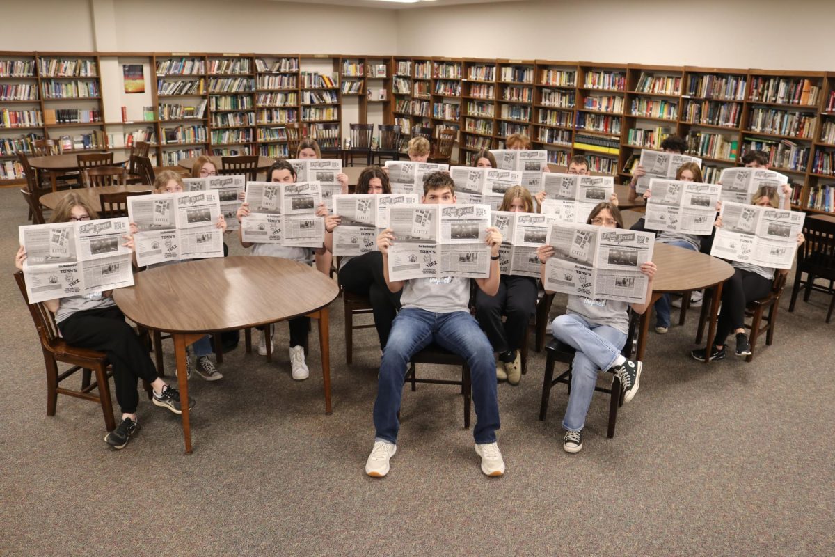 The look: Smoldering behind the newspaper, The FHS Press Staff recreates Mr. Fitzpatrick’s iconic profile picture. The newspaper photo is not needed for publication, which allows the staff to have fun with poses.