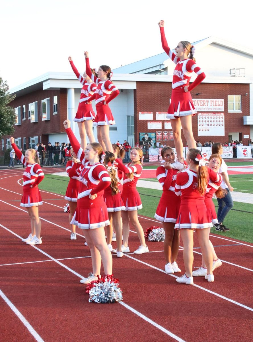 Standing tall: Shouting to the crowd, the cheer squad performs a stunt. The expanded squad spent weeks perfecting their moves during cheer camp and practices, which will run into the winter sports season. 

