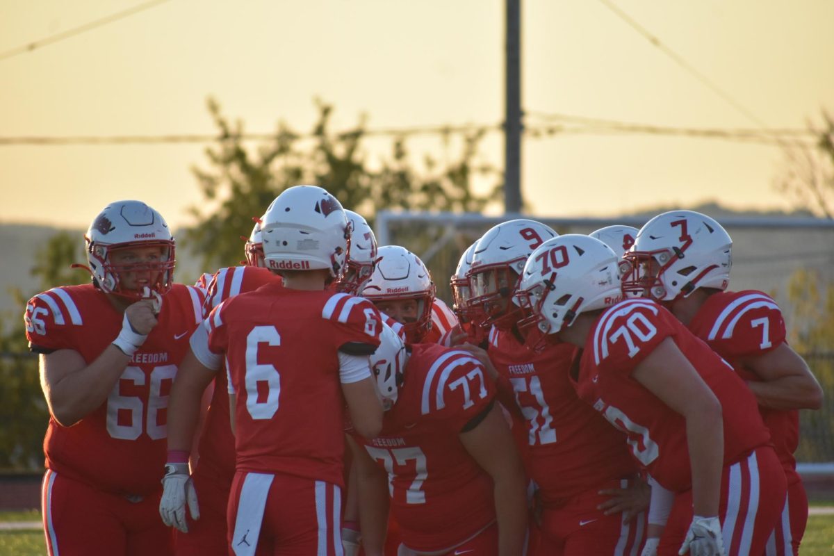 Huddle up: In a huddle, Karter Brown (10) explains the formation for their next play. The team listened intently to be able to get the first down and be closer to the endzone. 

