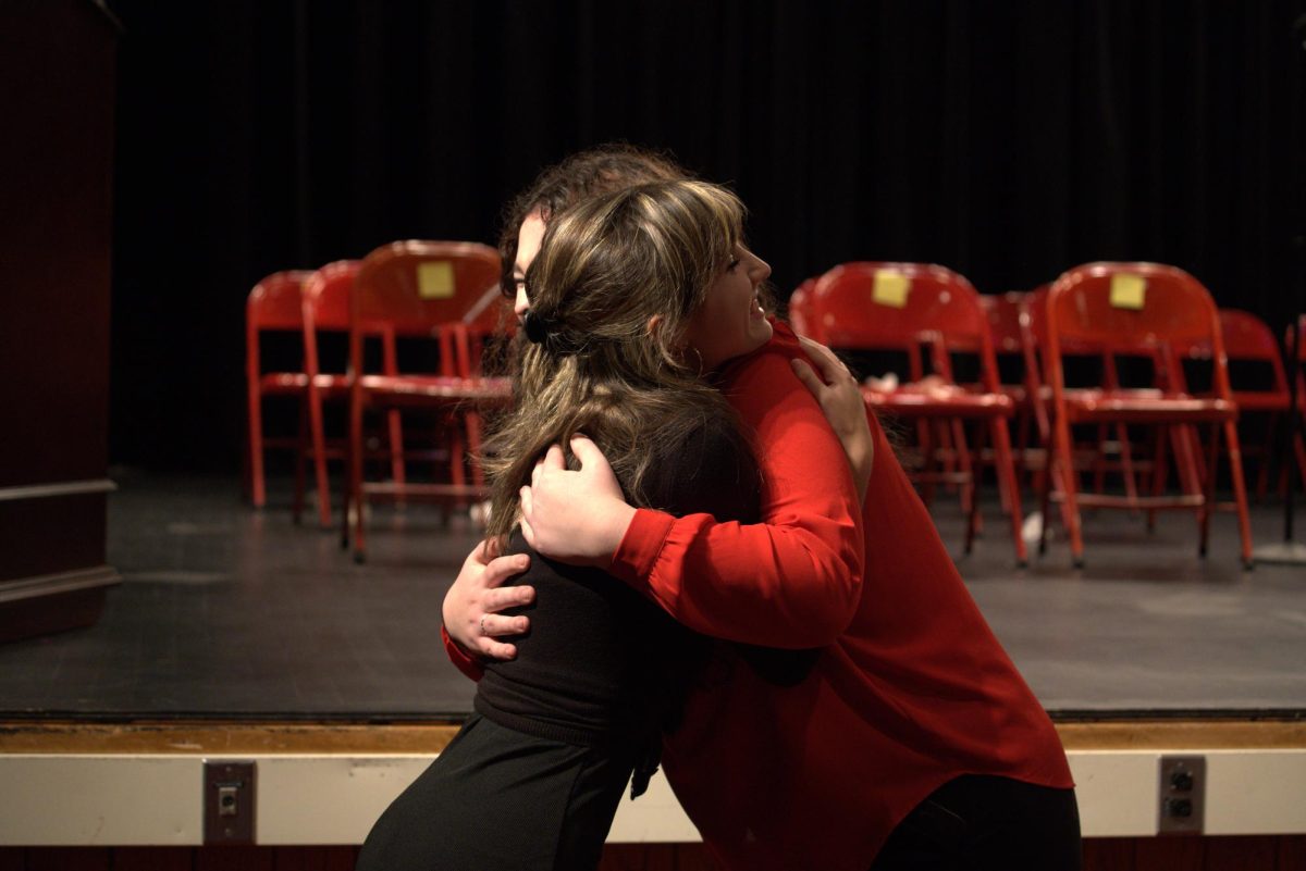 Celebrating achievement: After the NHS induction ceremony, Stella Haney (11) pulls Chelsea Parks (11) into a warm and joyful embrace. This celebratory moment showcases their hard work and dedication that has paid off.