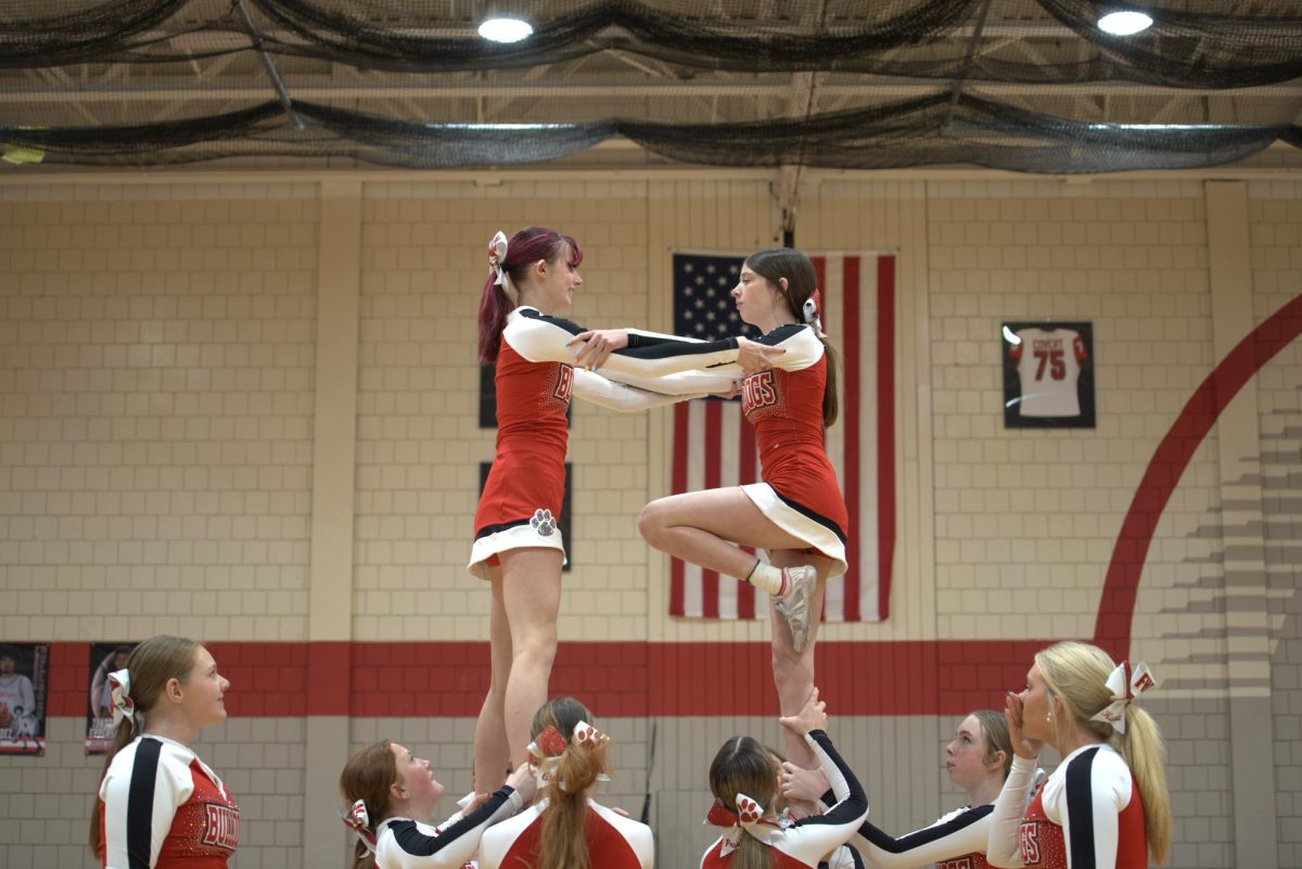 Trust, balance and teamwork: In the air, Aliana Milward (9) holds onto Savannah Hammel (9) in a stunt during their halftime performance.
