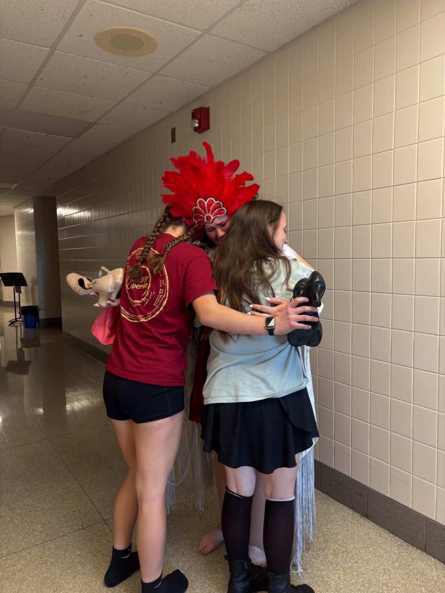 Group hug: Kaylee Anderson (8), Abigail Hunter (12) and Tori Loschinskey (10) embrace after Hunter gave them her shoes. This was done moments after the girls took their closing night bows.